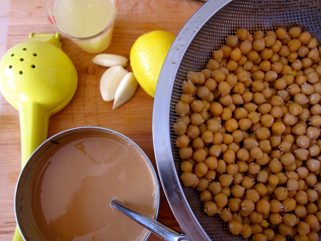 Rinse chickpeas, juice lemons, peel garlic.